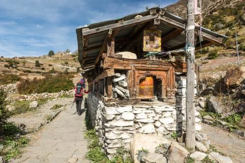 Trekker passing buddhist praying wheels. Stock Photos