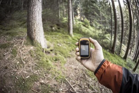 A trekker using gps among the forest in a cloudy day Stock Photos