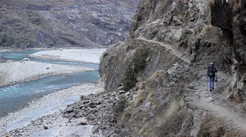 Trekker walking on thin trail on vertical rock Video stock 67647454