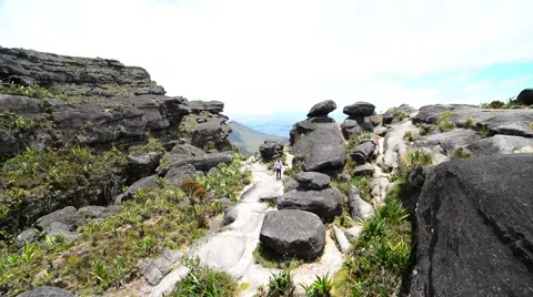 A trekker walking with on the top of Mount Roraima Stock Footage 58630791
