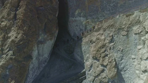 Trekkers moves down on narrow path, huge rocky cliffs at highland scree, Nepal Stock Footage 124679711