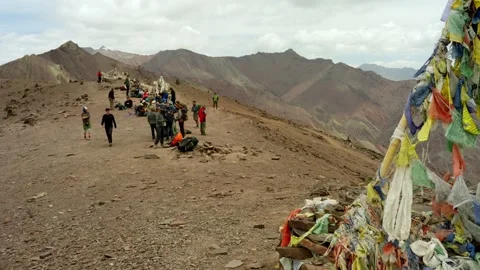 Trekkers rest on Himalayas high pass with prayer flags Stock Footage 280046291