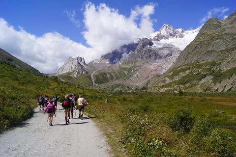 Trekkers walking on a mountain path in Val Veny, Aosta Valley (Italy) Stock Photos