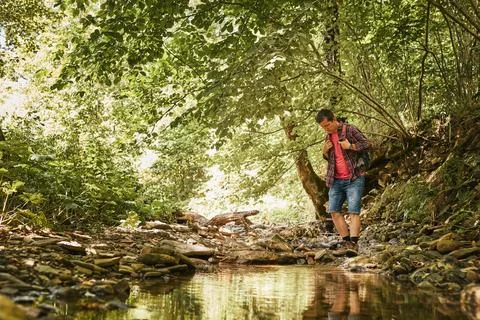 Trekking with backpack concept image. Backpacker in trekking boots crossing.. Stock Photos