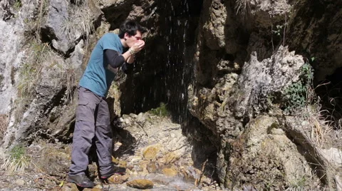 Trekking - mountain a person is drinking the waterfall Stock Footage 49126089
