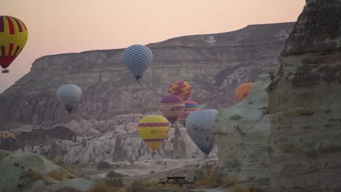 Tremendous balloons with baskets float in air above hills Stock Footage 146577450