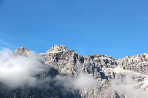 Tremendous mountain peak in clouds Stock Photos