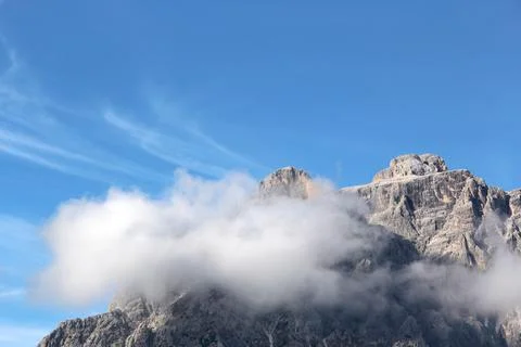 Tremendous mountain peak in clouds Stock Photos