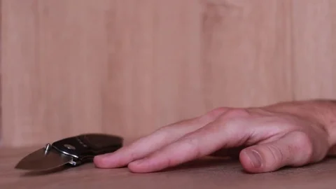 Tremored hand trying to take jack-knife Stock Footage 83532750
