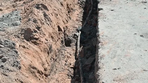 A trench is being dug in the ground as part of the construction process. The Stock Footage 339016406