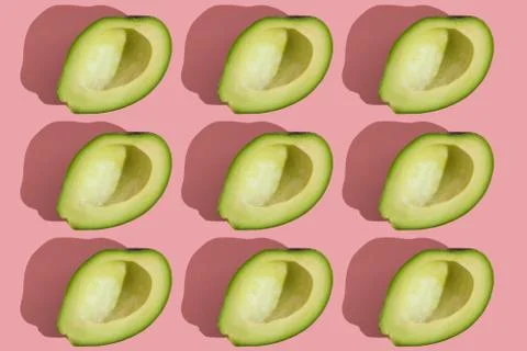 Trending style pattern of half seedless green avocado on pink background with Stock Photos