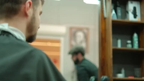 Trendy bearded barber cuts bearded man's hair with a clipper in barbershop. Men Stock Footage 236634729