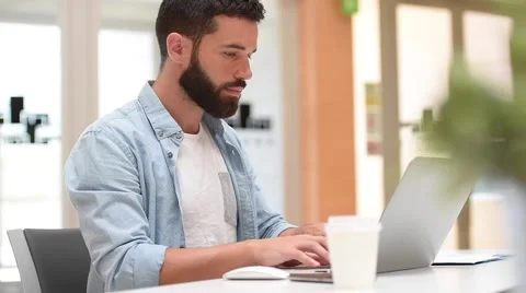 Trendy bearded guy in office working on laptop Stock Footage 64733793