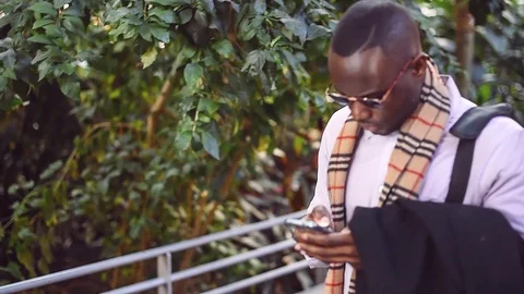 Trendy black man using phone at train station Stock Footage 86468248