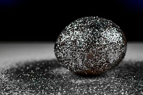 Trendy easter background with shiny gray colored egg and with glitters around Stock Photos