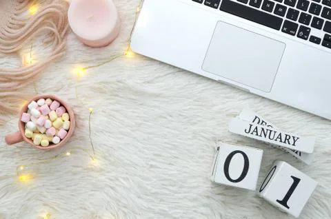 Trendy flat lay cozy composition with Computer notebook, candle, marshmallow,and Stock Photos