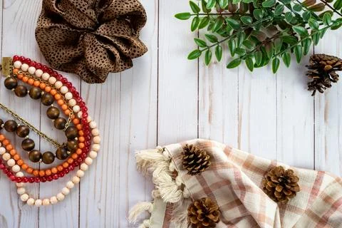 Trendy flat lay top down view with a brown scrunchie, pine cones, plaid tow.. Stock Photos