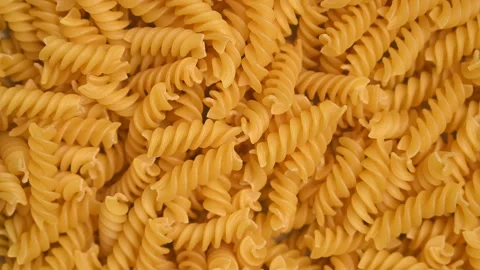 Trendy flat view closeup rolling yellow macaroni. Top view, flat lay. Stock Footage 161622025