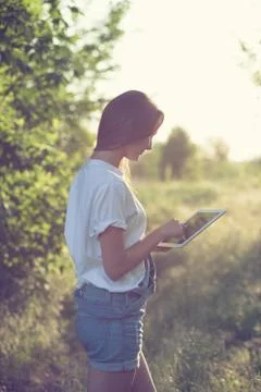 Trendy girl using a tablet pc outdoors Stock Photos