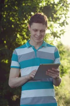 Trendy guy using a tablet pc outdoors Stock Photos