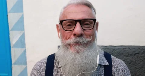 Trendy hipster man doing video call while wearing earphones Stock Footage 149116524