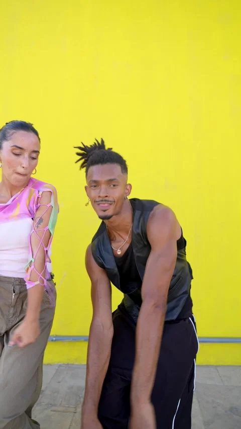 Trendy interracial couple dancing and smiling together 動画素材 345933751