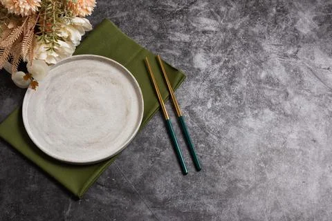 Trendy minimal tableware setting with the gray plate and golden chopsticks Stock Photos