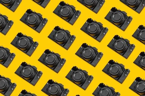 Trendy pattern of retro cameras on a yellow background. Horizontal background Stock Photos
