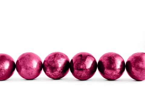 Trendy pink Easter eggs lined on white background. Close-up. Stock Photos