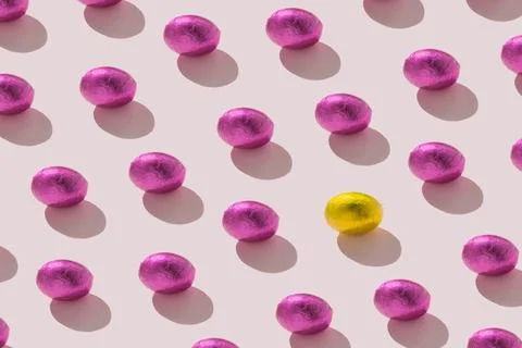 Trendy seamless flat lay pattern of foil eggs on pastel pink background min.. Stock Photos