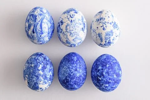Trendy six Easter eggs with classic blue gradient effect on white background Stock Photos