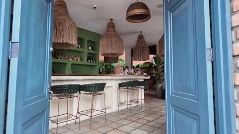 Trendy Tropical Bar Interior with Green Shelves and Straw Lamps in Cali Colombia Stock Footage 337138065