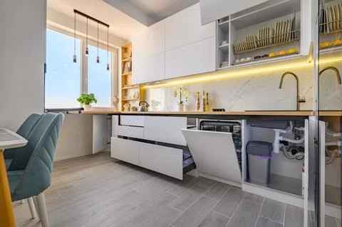 A trendy white kitchen with drawers pulled out to their full length Foto stock