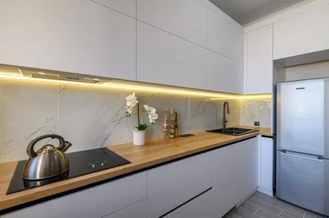 A trendy white studio with a functional kitchen Stock-Fotos