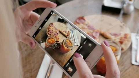 Trendy Woman With Mobile iPhone Camera In a Pizzeria Make Photo Of Food Pizza Stock Footage 87204349