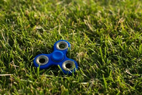 Tri Fidget Hand Spinner on the grass Stock Photos