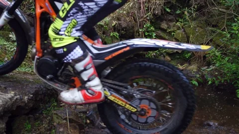 Trial biker balancing while riding up a stream. Stock Footage 93783481
