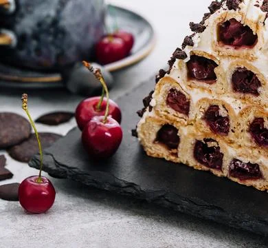 Triangle cherry cake with cream and chocolate sprinkles Stock Photos