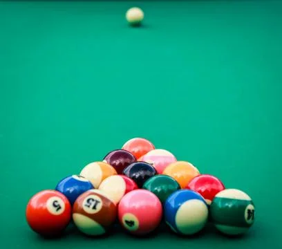 Triangle of colored pool billiard balls on green cloth Stock Photos