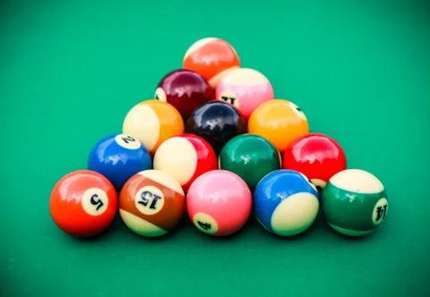 Triangle of colored pool billiard balls on green cloth Stock Photos