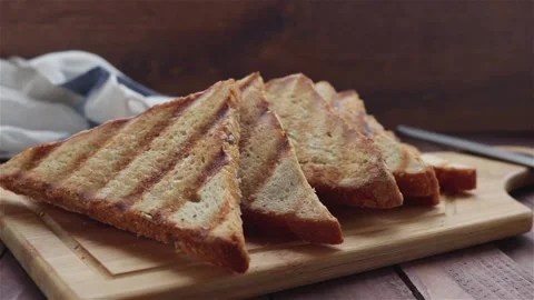 Triangle grilled bread on cutting board panning shot Stock-Footage 109037674