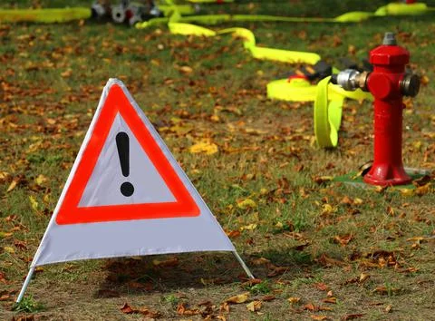 Triangle with large exclamation mark and a fire hydrant Stock Photos