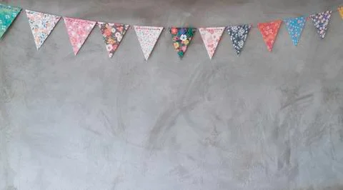 Triangle papers hanging on the grey wall decoration in house Stock Photos