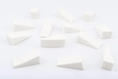 Triangle shaped make up sponges in random order on white background Foto stock