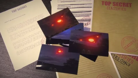 Triangle Shaped UFO files on a table with photographs Stock Footage 156364580