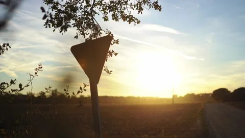 Triangle sign in a beautiful meadow during the sunset Stock Footage 324753892