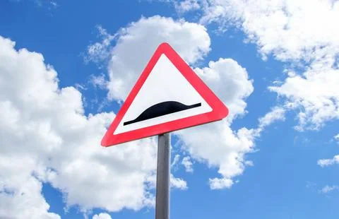 Triangle speed bump road sign against the blue sky Stock Photos