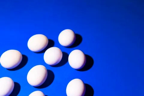 Triangle of white eggs on a deep blue background Stock Photos