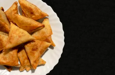 Triangular Arabic chicken samosa on black background with copy space Foto stock