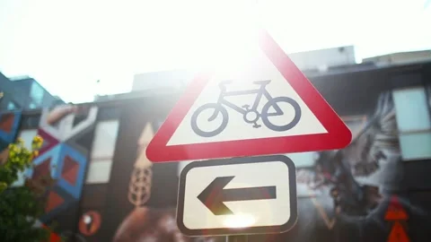 A Triangular Bicycle Sign with a Colorful Mural in the Background Stock Footage 140356022